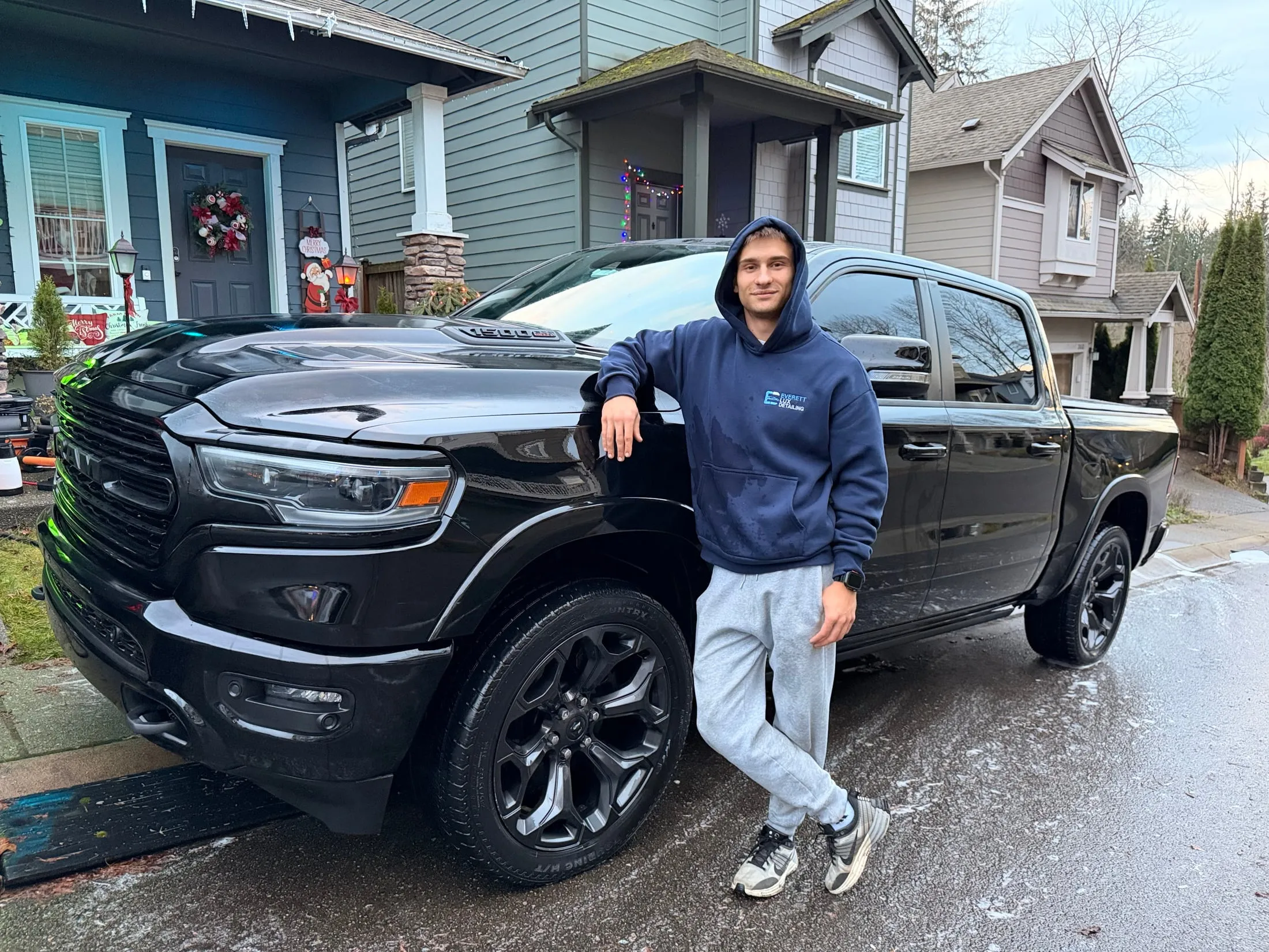 Detailer beside a freshly washed black Ram pickup